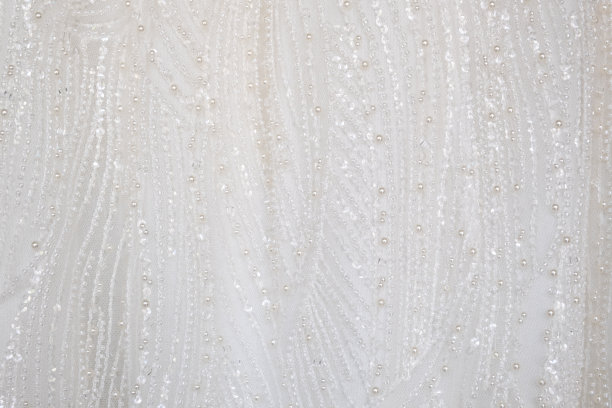 近距离拍摄的白色奢华礼服和闪光图案细节纺织礼服与女性新娘使用。时尚与服装背景概念。图片下载