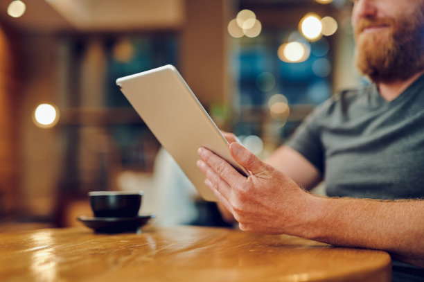 一名不知名的商人在咖啡馆使用平板电脑进行远程工作的照片图片下载