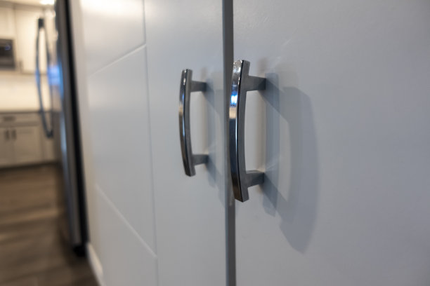 灰色橱柜门把手的低角度视图，位于带有精美硬木地板的大厨房内图片下载