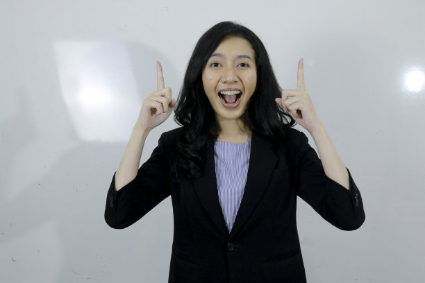 商业年轻的亚洲女孩开心地用手指着上面的空空如也。图片下载