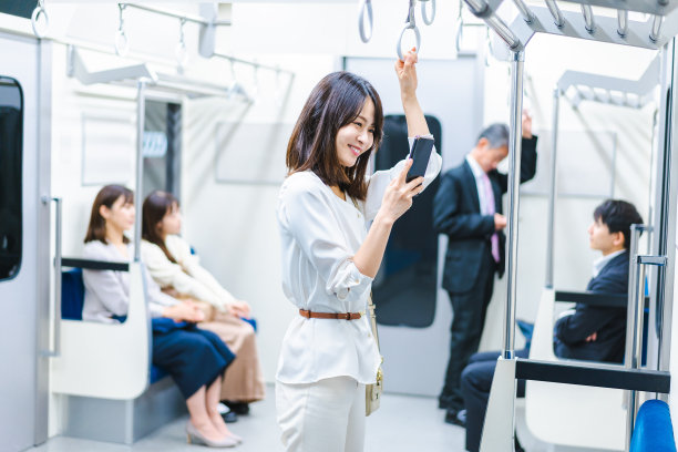 一位年轻女子在火车上使用智能手机图片下载