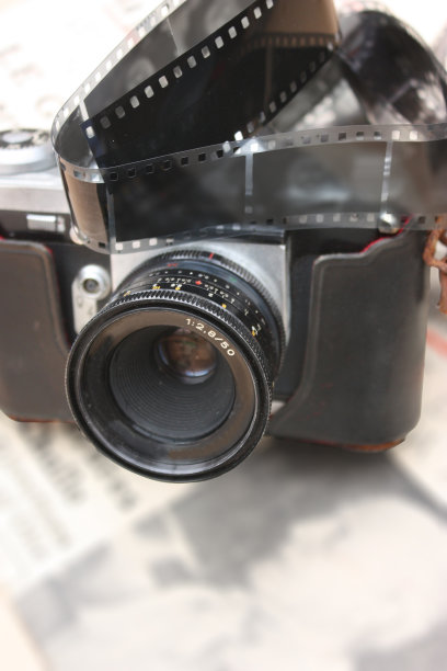 旧胶卷相机照片胶卷在旧报纸上图片下载