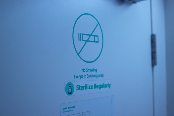 万隆的一家胶囊旅馆上写着“禁止吸烟”的标志，上面有“定期消毒”的文字和“疏散路线”的文字图片下载