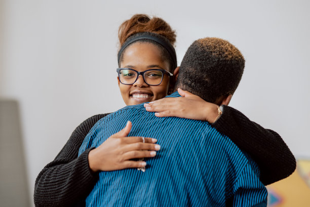 男人拥抱他的女朋友，妻子，幸福地举起，在公寓的背景中拍摄的腿与纸箱，夫妇搬进新房子图片下载