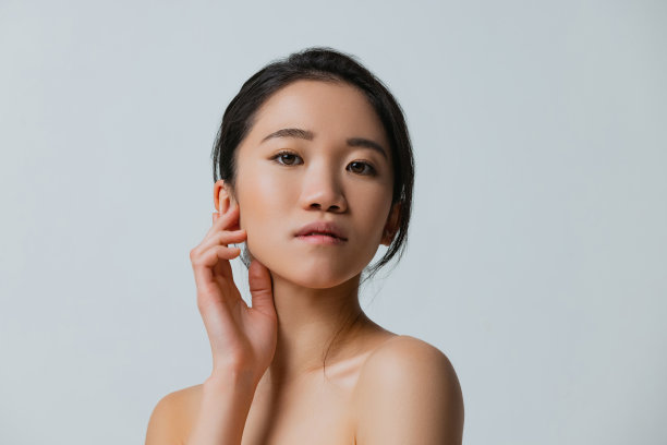 美丽的亚洲女孩与自然化妆摆孤立在灰色工作室背景的半长肖像图片下载