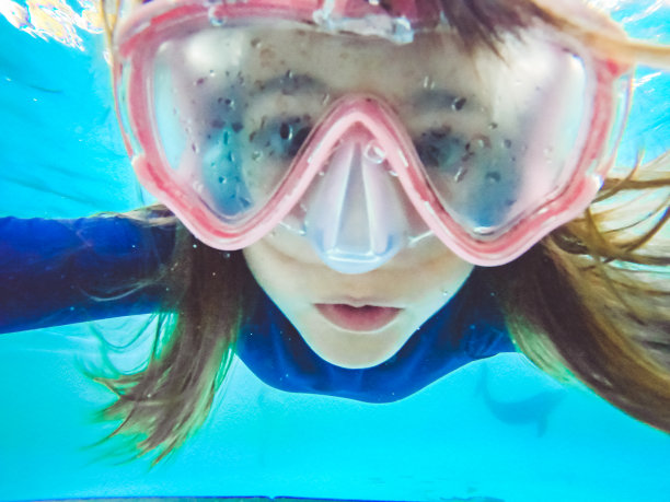 有趣的女孩在水下戴着游泳镜在游泳池里，好玩图片下载