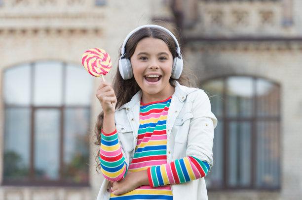 最快乐的一天。女生和棒棒糖。孩子的创新教育。快乐的儿童的一天。健康的生活方式。戴着耳机的快乐孩子。学生听音乐和唱歌。回到学校。快乐美丽的户外图片下载