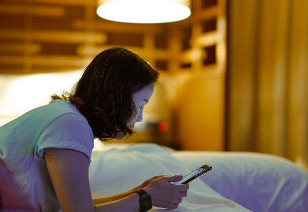 女人在床上使用手机上网成瘾图片下载
