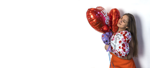 情人节快乐!一个年轻的女人拿着一个心形的气球。副本的空间。图片下载
