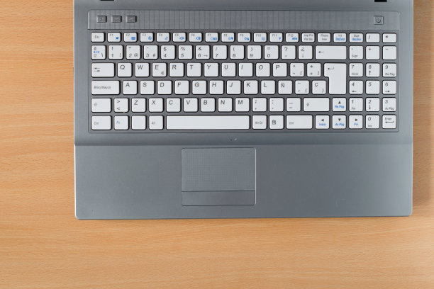 浅灰色的笔记本电脑键盘在木桌上图片下载