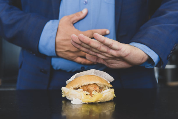 消化不良因劣质食物引起的肠道消化不良商人因吃垃圾食品而胃痛。吃太多的人拒绝吃汉堡图片下载