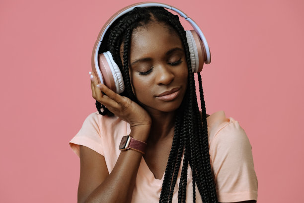 美丽的年轻女子跳舞和听音乐，戴着耳机图片下载