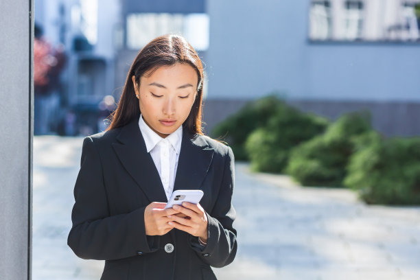 亚洲商业妇女使用电话，一个妇女在办公中心附近，散步在城市的休息图片下载