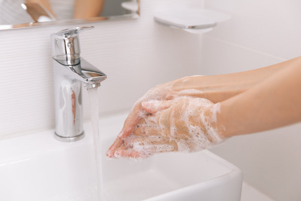 在水龙头下洗手。手部卫生概念细节。用肥皂洗手以预防冠状病毒的传播，防止冠状病毒在公共卫生间或公共卫生间的卫生传播图片下载