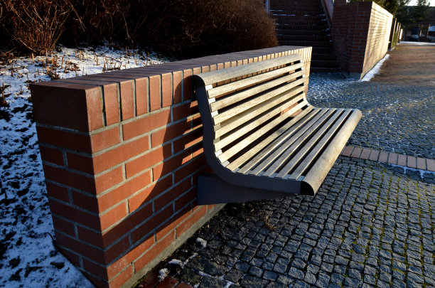 楼梯和栏杆的外露砖光滑表面。u形砖挡土墙角落的金属栏杆和长凳。凹进去的灯照亮了行人的脚底图片下载