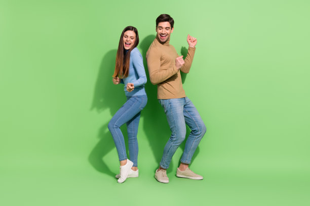 有趣的照片，愉悦的灵感夫妇享受夜总会迪斯科舞厅穿休闲装孤立的绿色背景图片下载