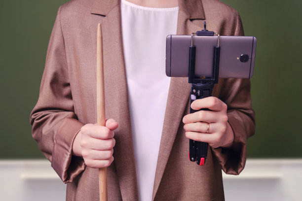 女教师用电话在学校的黑板上在线上课图片下载