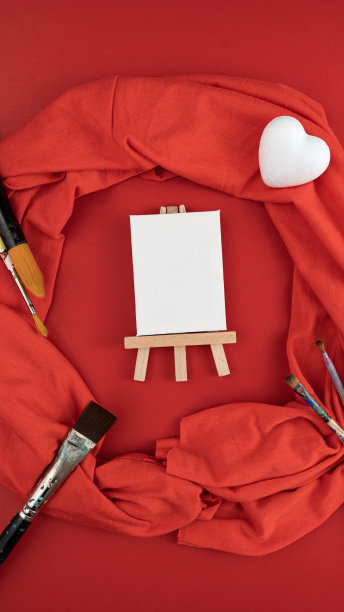 画架、白色心形泡沫塑料、画笔和红色丝巾图片下载