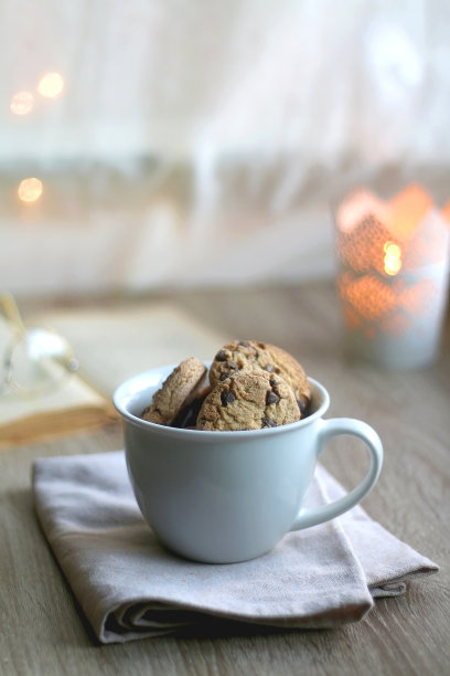 一碗饼干，书，玻璃杯和蜡烛图片下载