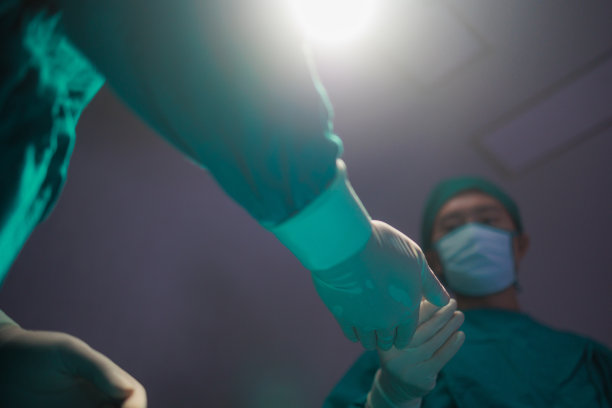 亚裔男性医生在手术室做手术。图片下载