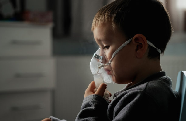 小男孩在家中接受吸入治疗时使用喷雾器图片下载