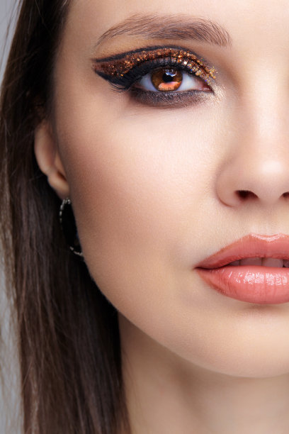 女性脸的特写镜头与时尚的金色闪亮的眼睛图片下载