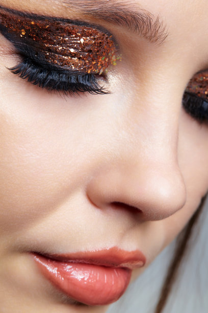 女性脸的特写镜头与时尚的金色闪亮的眼睛图片下载