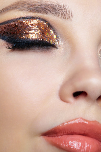 女性脸的特写镜头与时尚的金色闪亮的眼睛图片下载