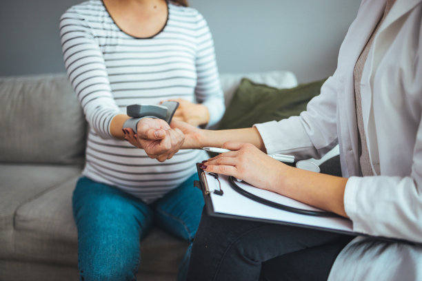 医生为年轻孕妇测量血压图片下载