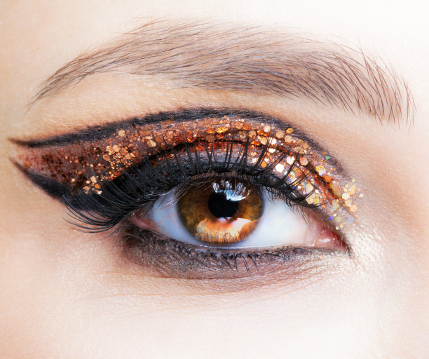女性脸的特写镜头与时尚的金色闪亮的眼睛图片下载
