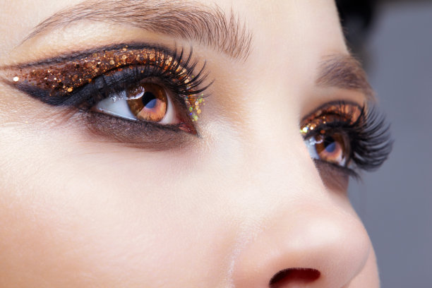 女性脸的特写镜头与时尚的金色闪亮的眼睛图片下载