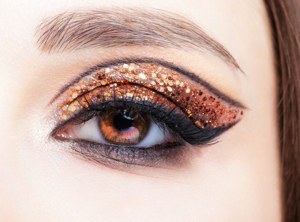 女性脸的特写镜头与时尚的金色闪亮的眼睛图片下载