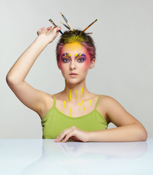 年轻女子的肖像在桌子摆姿势，头发上有刷子。图片下载