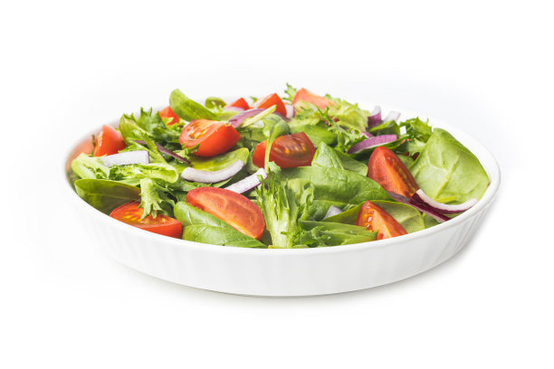 在灰色的桌子上，白色的碗里盛着绿色的沙拉图片下载