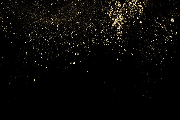 黑色背景上的金色粉末爆炸。图片下载