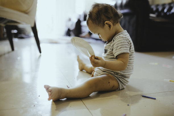 可爱的宝宝在客厅里玩玩具和看书图片下载