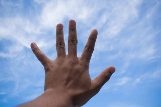 左手张开在明亮的蓝天白云中图片下载