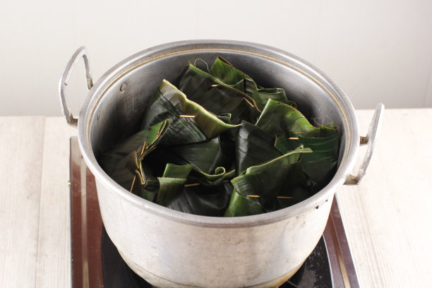 烹饪工艺:亚洲女性手开蒸盖，里面有“Pepes Ayam”，自然烟熏。Pepes Ayam是用香蕉叶包裹的香料鸡图片下载