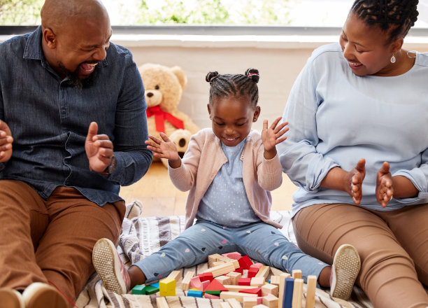 一个小女孩和她的祖父母在家里玩积木的照片图片下载