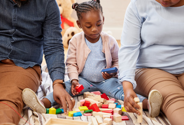 一个小女孩和她的祖父母在家里玩积木的照片图片下载