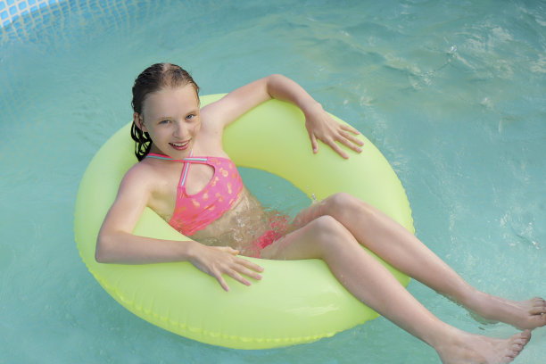 这个女孩在游泳池里快乐地游泳。图片下载