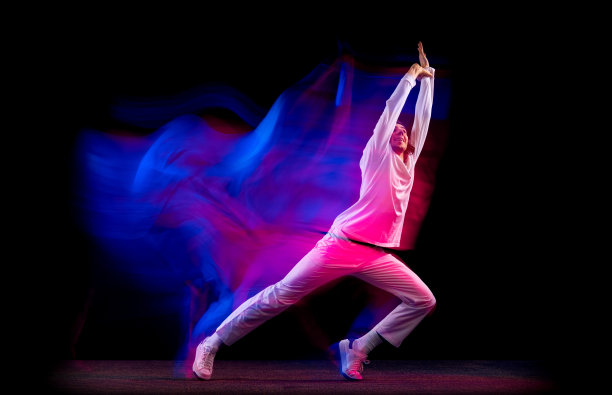 动态肖像男性嘻哈舞者孤立在黑暗的背景下混合霓虹灯跳舞。青年文化，嘻哈，运动，时尚，时尚，行动。图片下载