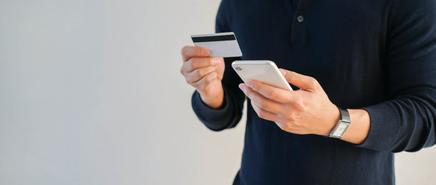 近距离的成年人手持智能手机在商场网站上选择或选择商品，并使用信用卡支付订单，现代舒适的生活理念图片下载