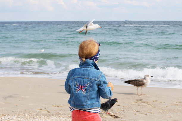 可爱的小女孩站在海滩股票照片图片下载