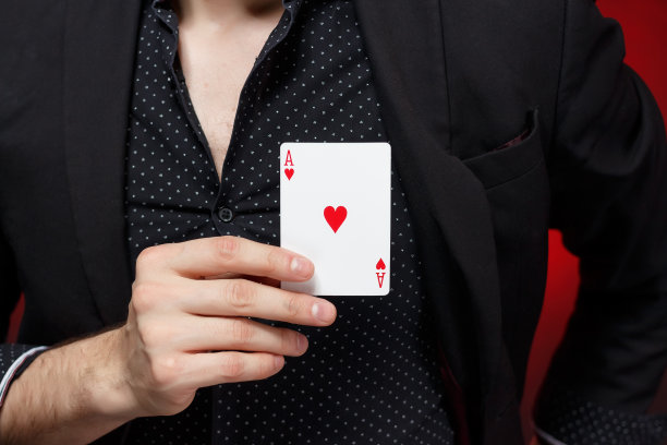 人在胸口(心脏)上显示红桃a。红色和黑色的背景。情人节，爱的表白。图片下载