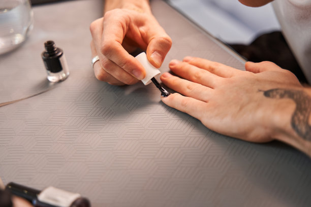 一个有纹身的白种人正在家里修指甲，准备给自己换一个新形象图片下载