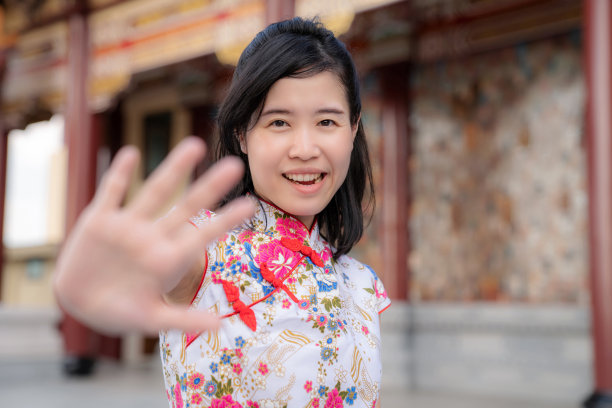 美丽的亚洲妇女的肖像穿着衣服和微笑在中国新年节日与模糊的背景。给你好5。人们的旅行生活方式在户外。图片下载