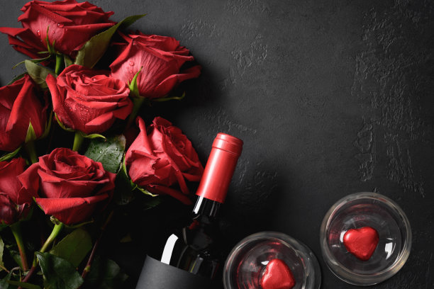 一束红玫瑰和一份礼物。情人节贺卡。图片下载