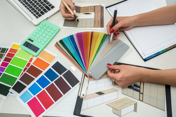 两位身穿白色衬衫的女员工在宽敞的桌子上设计新房间图片下载