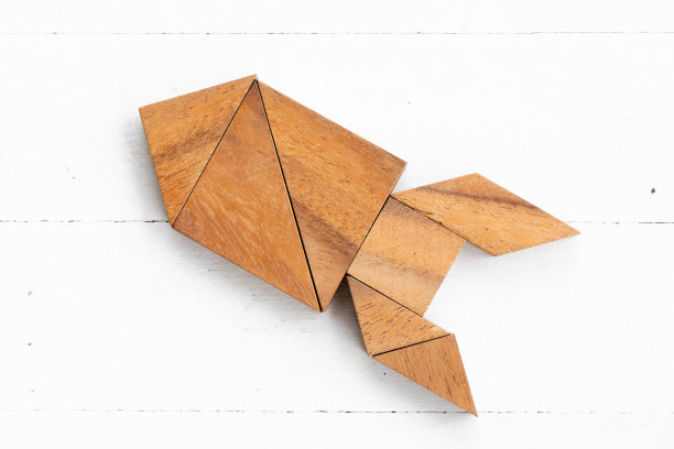 在白色木材背景上的火箭或导弹形状的木头七彩拼图图片下载